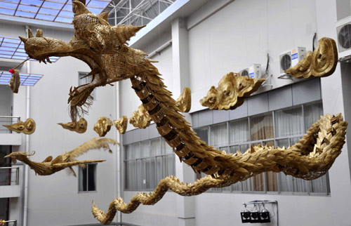 Photo taken on Jan. 27, 2010 shows the hand-woven straw handicraft of two pairs of 30-meter-long dragons and phoenixes with the connotation of bringing forth auspices and prosperity, on the building of the Liuzhou Museum in Liuzhou, southwest China&apos;s Guangxi Zhuang Autonomous Region. [Xinhua]