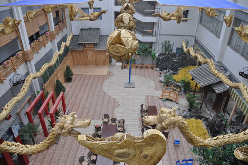 Photo taken on Jan. 27, 2010 shows the hand-woven straw handicraft of two pairs of 30-meter-long dragons and phoenixes with the connotation of bringing forth auspices and prosperity, on the building of the Liuzhou Museum in Liuzhou, southwest China&apos;s Guangxi Zhuang Autonomous Region. [Xinhua]