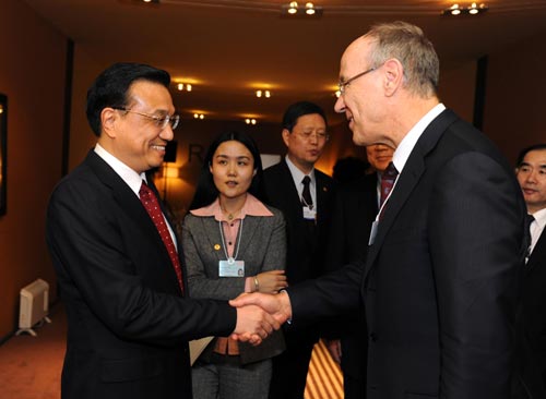 Chinese Vice Premier Li Keqiang (L, Front) shakes hands with Director-General of the World Intellectual Property Organization Francis Gurry during their meeting in Davos, Switzerland, Jan. 28, 2010. [Xinhua]