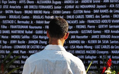 A United Nations staff member mourns for his colleagues dead in the earthquake in front of the name wall for victims during a memorial service in Port-au-Prince, capital of Haiti, Jan. 28, 2010. The UN confirmed on Thursday that 85 of it staff members lost their lives in the earthquake. [Xinhua] 