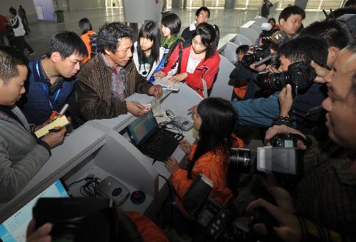 A passenger (3rd L) waits for his real-name train ticket to be verified at the waiting area for the L7688 train going from Guangzhou to Shaoyang of central-south Hunan Province, in Guangzhou, capital of south China&apos;s Guangdong Province, Jan. 29, 2010.