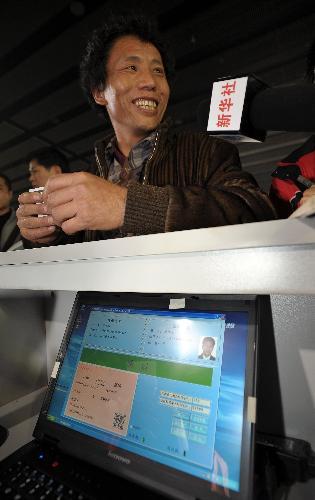 A passenger waits for his real-name train ticket to be verified at the waiting area for the L7688 train going from Guangzhou to Shaoyang of central-south Hunan Province, in Guangzhou, capital of south China&apos;s Guangdong Province, Jan. 29, 2010. 