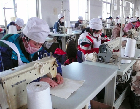Women employees work in a privately-run garment factory in Houma city of Shanxi Province on December 26, 2009.