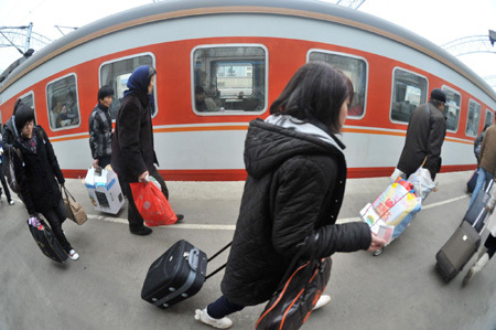 Passengers board a train at the Railway Station in Hefei, capital city of east China's Anhui province on January 30, 2010. China's Spring Festival travel peak season, or 'chun yun' in Chinese, kicks off today. [Photo/Xinhua]