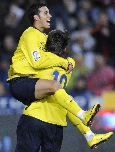 FC Barcelona's Pedro Rodriguez, left, celebrates after scoring against Sporting de Gijon during their Spanish La Liga soccer match at El Molinon stadium in Gijon northern Spain, Saturday Jan. 30, 2010.(Xinhua/Reuters Photo)