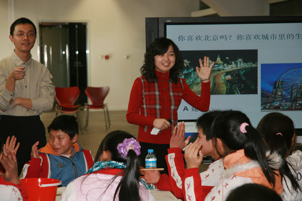A teacher from UCCA teaching the students how to paint in the workshop on Jan.31 2010.[China.org.cn]