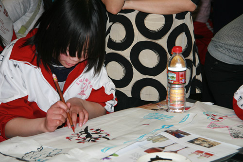 Liu Yu, 12, grade six, in Dongba Experimental Primary School, painting flowers in the workshop. [China.org.cn]