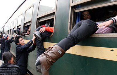 Two railway officers helped Spring Festival passengers board the train through windows.