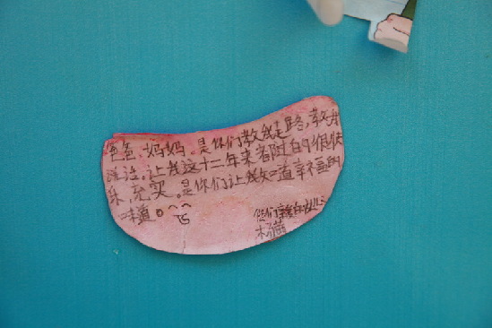 A girl from Wenchuan 1st primary school writes down her gratitude to her parents on paper. She says: “dear Mama and Papa, you taught me how to speak and walk, make my life wonderful, and let me know what happiness is”. [China.org.cn]