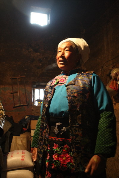 A Qiang woman shows the rice she received from the government in Buwa village, Sichuan Province. [China.org.cn/ Zhao Xi]