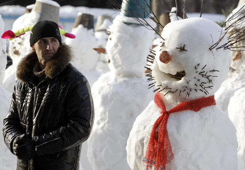 A man looks at a snowman built as part of a display on a street in Moscow January 31, 2010. [Xinhua/Reuters]