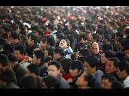 Passengers queue to buy train tickets to go home at the Shanghai Railway Station January 26, 2010. China's Spring Festival travel peak season, or 'chun yun' in Chinese, kicks off today. [Xinhua]