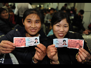 Two passengers show their real-name tickets in Guangzhou, capital of south China's Guangdong Province, Jan. 21, 2010. Southern Guangdong Province launched the pilot real-name ticket system on Jan. 21 morning amid China's efforts to curb ticket hoarding by scalpers. [Xinhua]