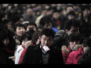 Passengers wait to board a train at the Railway Station in Shenyang, capital city of northeast China's Liaoning Province on January 20, 2010. [Sina.com.cn]