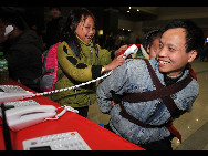 Lu Laofa (R), a 40-year-old migrant worker from southwest China's Guizhou Province, and his children make a free phone call with their relatives at the railway station of Hangzhou capital of east China's Zhejiang Province, Jan. 31, 2010. The railway station provides free phone call service for migrant workers during the Spring Festival travel peak. Some 20 million migrant workers in Zhejiang Province began to return home for Spring Festival which falls on Feb. 14 this year. [Xinhua]