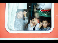Several kids sit in a train at Harbin railway station in northeast China's Heilongjiang province on January 30. [Xinhua]