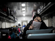 A girl reads a book in a train on January 9, 2010, northeast China's Liaonin Province. Universities in Liaonin Province has started winter vacation. [Sina.com.cn]