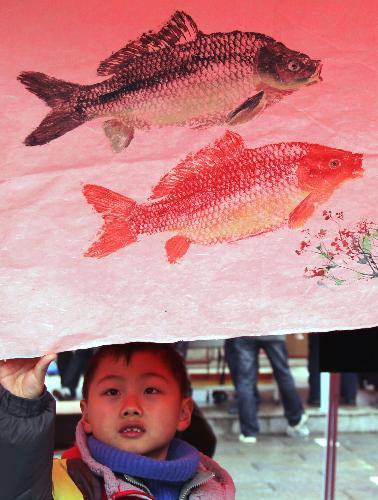 A boy views a New Year picture at a New Year picture festival held on the Zhonghua Gate Square in Nanjing, capital of east China's Jiangsu Province, February 1, 2010.