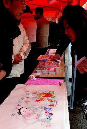 People buy New Year pictures at a New Year picture festival held on the Zhonghua Gate Square in Nanjing, capital of east China's Jiangsu Province, February 1, 2010. A New Year picture festival was held here on Monday with a selection of top quality New Year pictures on show.