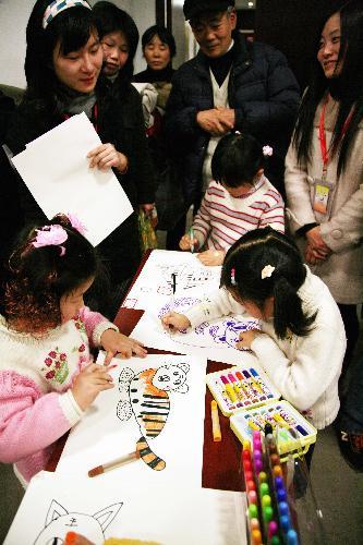 A group of children are engrossed in drawing cartoon paintings of tigers in Nanjing, east China's Jiangsu Province, January 23, 2010. 