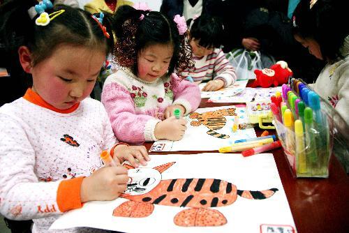 A group of children are engrossed in drawing cartoon paintings of tigers in Nanjing, east China's Jiangsu Province, January 23, 2010.