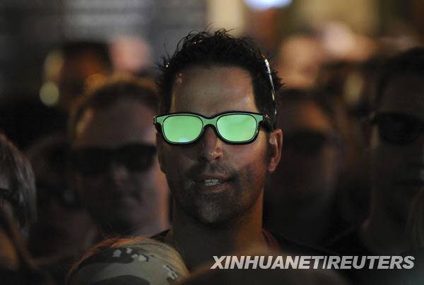 A football fan wears 3D glasses as he watches a live 3D TV football match between Arsenal and Manchester United, in a pub in London January 31, 2010. [Xinhua/Reuters]