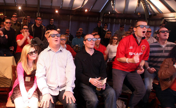 Football fans wear 3D glasses as they watch a live 3D TV football match between Arsenal and Manchester United, in a pub in London January 31, 2010. [Chinanews.com.cn]