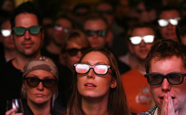 Football fans wear 3D glasses as they watch a live 3D TV football match between Arsenal and Manchester United, in a pub in London January 31, 2010. [Chinanews.com.cn]