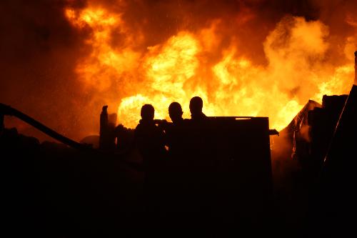 People try to extinguish the fire in Bakara Market, where fuel in barrels and tanks is sold, in Mogadishu, capital of Somalia, Feb. 2, 2010. The fire destroyed hundreds of thousands of dollars&apos; worth of goods, mainly petrol and diesel. [Ismail Warsameh/Xinhua] 