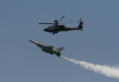 A Republic of Singapore Air Force Apache helicopter AH-64 (top) and a F-16 fighter jet demonstrate in midair during a display at the Singapore Airshow 2010 in Singapore on Feb. 2, 2010. More than 800 exhibitors from 40 countries and regions participated in the airshow, which lasts from Feb. 2 to 7. [Gao Chuan/Xinhua