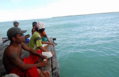 Local residents sit on the dock where the sunken boat departed, in Moluccas islands in eastern Indonesia, Feb. 2, 2010. Rescuers continued to search for the 23 missing passengers of the sunken Dolphin speed boat off Moluccas islands on Tuesday. There were more than 30 people including 24 Chinese citizens on board the Dolphin speed boat when it sank on Jan. 27. [Xinhua/Yue Yuewei]