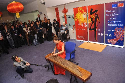 An actress performs Chinese guqin, a seven-stringed plucked musical instrument in some ways similar to the zither, during a cultural presentation of the Chinese lunar new year at the European Parliament headquarters in Brussels, capital of Belgium, Feb. 2, 2010. [Wu Wei/Xinhua] 