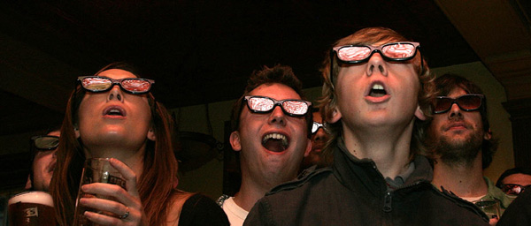 Football fans wear 3D glasses as they watch a live 3D TV football match between Arsenal and Manchester United, in a pub in London January 31, 2010. [Photo: Chinanews.com.cn]