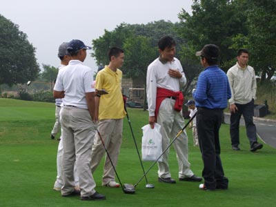 A father offers some final words of encouragement and advice as a group waits at the first to tee off their practice round.
