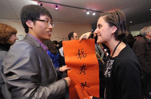 A woman receives a Chinse Spring Festival couplets during a cultural presentation of the Chinese lunar new year at the European Parliament headquarters in Brussels, capital of Belgium, Feb. 2, 2010. 