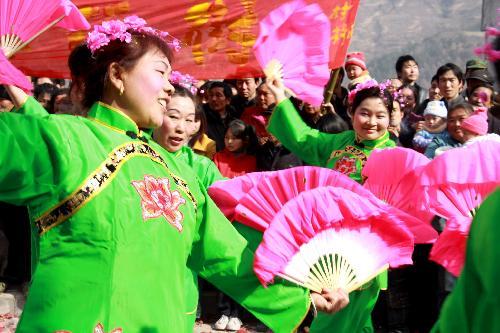 Local performers of Yangko Dance put on a pageant show of traditional folklore in celebration of harvest and greeting new year, at Jiangkou Town, Liuba County, northwest China's Shaanxi Province, Feb. 1, 2010. 