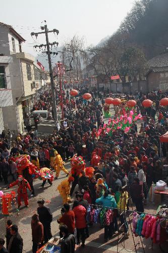 Plethora of local villagers line the street to watch the pageant show of traditional folklore in celebration of harvest and greeting new year, at Jiangkou Town, Liuba County, northwest China's Shaanxi Province, Feb. 1, 2010. 