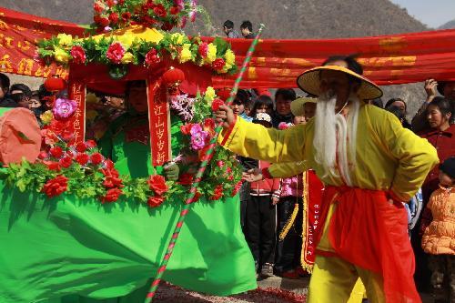 Local performers of festooned barge dance put on a pageant show of traditional folklore in celebration of harvest and greeting new year, at Jiangkou Town, Liuba County, northwest China's Shaanxi Province, Feb. 1, 2010. 