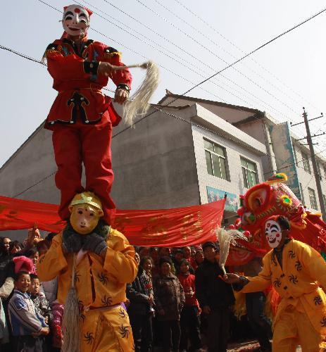 Local performers of Lion Dance put on a pageant show of traditional folklore in celebration of harvest and greeting new year, at Hongwu Village, Liuba County, northwest China's Shaanxi Province, Feb. 1, 2010.