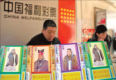 A salesman at a welfare lottery outlet in Liaocheng, Shandong province, holds lottery tickets that use the image and sermons of Confucius. [Kong Zheng]