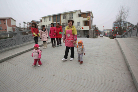 Villagers walks in a newly reconstruct Gaodun tourist village, Chongzhou city, southwestern Sichuan province, January 28, 2010. Gaodun village was reconstructed with aid from the Chongqing municipal government. Local government made this village into a leisure tourist spot based on its natural and cultural resources. [Xinhua]