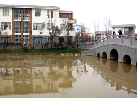 Villagers take photos on a bridge in Gaodun tourist village in Gaodun, Chongzhou city, southwestern Sichuan province, January 28, 2010. [Xinhua]