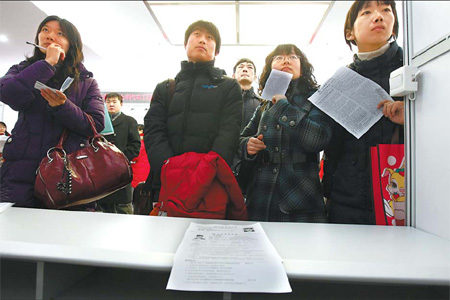 Job seekers line up at a job fair in Beijing. The city's universities plan to adopt a more flexible credit system to alleviate seasonal pressures on graduates.