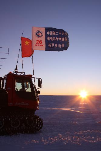 Vehicles carrying members of an exploration squad of the 26th Chinese Antarctica expedition team stop for a break as the sun is setting on the horizon after months of polar day period in Grove Mountains, Antarctica, Feb. 2, 2010. (Xinhua/Cui Jing)