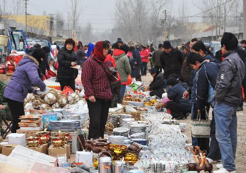 Local villagers in hustle and bustle throng to the rural bazaar of Spring Festival to select and purchase the new goods for use during the Spring Festival, in Shanting Town, Zaozhuang, east China's Shandong Province, Feb. 2, 2010. (Xinhua