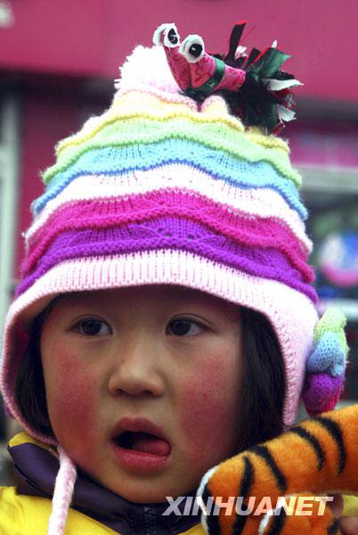 A young girl bought 'colorful chicks'. According to the local custom, on Lichun (Beginning of Spring), children always wear colorful chicks on their hat for a lucky New Year and good health. 