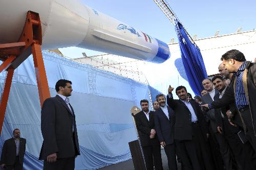 Iranian President Mahmoud Ahmadinejad (C) gestures towards a model of Iran&apos;s new domestically-built light booster rocket, named Simorgh, in Tehran, Iran, Wednesday, Feb. 3, 2010. [Xinhua]