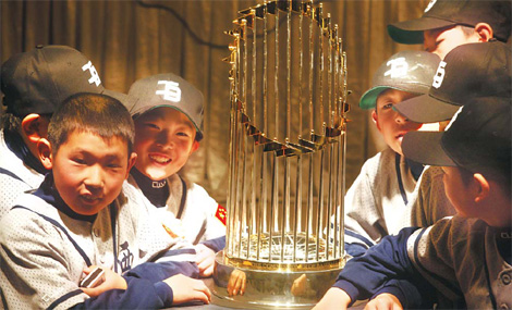 Students from several primary schools in Beijing check out the New York Yankees 2009 World Series Championship Trophy at the Kunlun Hotel yesterday. A 300-team youth league will be launched in China this year and the Yankees will send coaches and players to instruct the champions of the competition. Yang Shizhong