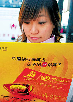 A customer in Beijing looks at promotional material for paper gold products. In a recent SGE survey, paper gold was ranked as the prefered means of investing in the commodity. [China Daily]