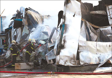 Firefighters deal with the aftermath of a blaze in Fengtai district yesterday morning. Traffic on the Third Ring Road was interrupted for much of the morning as a result of the fire. Mirror Evening News